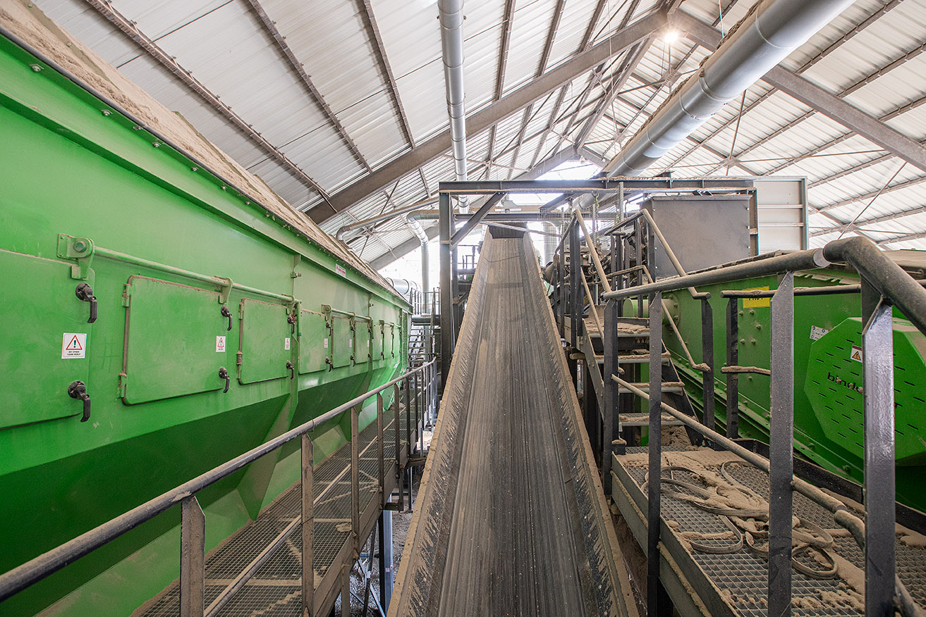 Groene sorteerlijn met transportband tussen de installaties